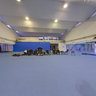 Two women sword fighting at the Italian Olympic training facility.